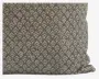 Rektangulær pude med en blød, fløjlsagtig overflade og et gentaget geometrisk mønster i lyse og mørke grå nuancer. Mønstret består af små, pilformede figurer, der er arrangeret i et ensartet, heldækkende design. Pudens kanter er let afrundede, og stoffet ser blødt og behageligt ud.