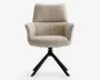 Moderne stol med høj, polstret ryg og armlæn, betrukket med lysebeige stof. Sædet er bredt og komfortabelt polstret. Stolen har en sort metalfod med fire skråtstillede ben, der giver stabilitet og et moderne udtryk.