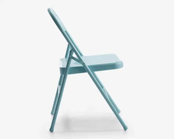 Sidevisning af en lyseblå klapstol lavet af metal med et enkelt og slankt design. Stolen har et fladt sæde og et lige ryglæn, rørformede ben og synlige hængsler til foldemekanismen. Overfladen er glat og blank.