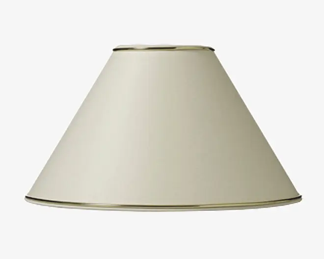 En konisk lampeskærm i en lys beige farve med en glat, mat overflade. Top- og bundkanten er afsluttet med en tynd, metallisk guldfarvet kant, som giver et diskret dekorativt præg. Skærmen har et enkelt og klassisk design, der passer til mange forskellige lampestativer og indretninger.