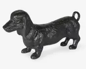 Blank sort hundefigur med lang krop, hængeører og krøllet hale, vist i sideprofil.