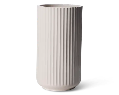 Høj, cylindrisk vase med mat, lysebeige overflade. Vasen har jævnt fordelte lodrette riller hele vejen fra top til bund, hvilket giver et moderne og tekstureret udtryk. Kanten er glat og let afrundet, og bunden er diskret buet for stabilitet.