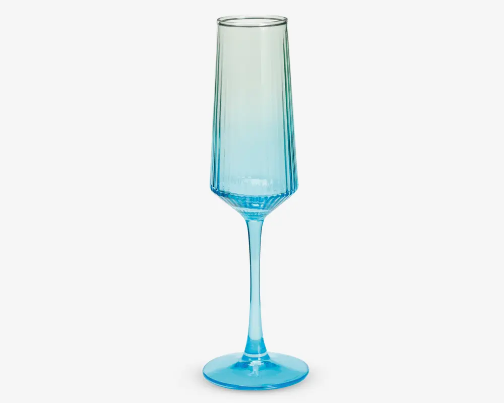 Et højt, slankt glas med sekskantet fod og lang stilk, der har en blå farvegradient, som går fra dyb blå i bunden til gennemsigtig ved kanten. Glasset har et moderne, geometrisk design med rene linjer og en glat overflade.