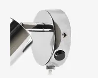 Nærbillede af en vægmonteret armatur med blank kromfinish. Armaturet har en cylindrisk arm, der er fastgjort til en rund baseplade. Der er en synlig skrue til montering, en sort trykknap og et rillet drejehjul i bunden til justering af vinkel eller position. Designet er stilrent og moderne, velegnet til nutidige indretninger.