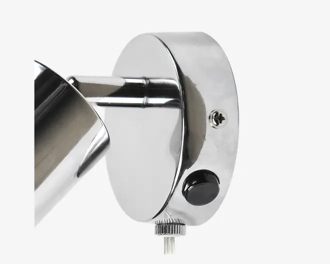 Nærbillede af en vægmonteret armatur med blank kromfinish. Armaturet har en cylindrisk arm, der er fastgjort til en rund baseplade. Der er en synlig skrue til montering, en sort trykknap og et rillet drejehjul i bunden til justering af vinkel eller position. Designet er stilrent og moderne, velegnet til nutidige indretninger.