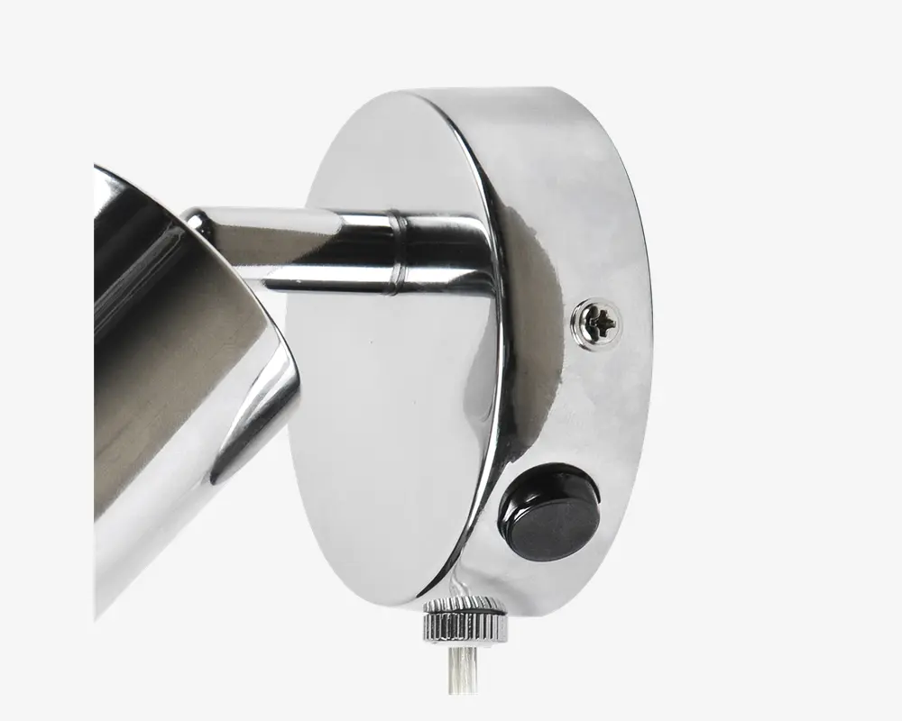 Nærbillede af en vægmonteret armatur med blank kromfinish. Armaturet har en cylindrisk arm, der er fastgjort til en rund baseplade. Der er en synlig skrue til montering, en sort trykknap og et rillet drejehjul i bunden til justering af vinkel eller position. Designet er stilrent og moderne, velegnet til nutidige indretninger.