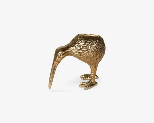 En dekorativ figur formet som en kiwifugl, lavet af et metallisk materiale med en blank guldfinish. Overfladen har detaljerede fjerstrukturer, og fuglen står på to ben med et langt, nedadbuet næb. Udtrykket er elegant og iøjnefaldende, velegnet til udstilling på hylder eller borde.