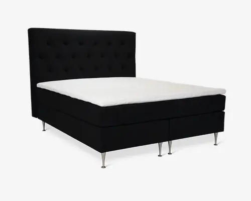 Sengen har et højt, polstret hovedgærde med knapdetaljer og er betrukket med mørkt stof. Bunden er delt i to sektioner og står på seks slanke, metalliske ben. Madrassen er udstyret med en hvid, blød topmadras, som giver en flot kontrast til den mørke bund og hovedgærde. Designet er moderne og elegant, velegnet til et nutidigt soveværelse.