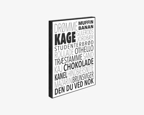 Rektangulært vægkunst med sort ramme, der har en hvid baggrund og forskellige danske ord relateret til kager og desserter trykt med fed, sort og grå skrift i store bogstaver. Teksten er arrangeret i forskellige skrifttyper og størrelser, hvilket giver et moderne og dynamisk typografisk udtryk.