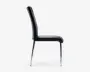 Sidebillede af en moderne stol med høj, let buet ryg og polstret sæde, begge betrukket med sort læder. Stolen har slanke, blanke metalben, der er let udadgående, hvilket giver et stilrent og moderne udtryk.
