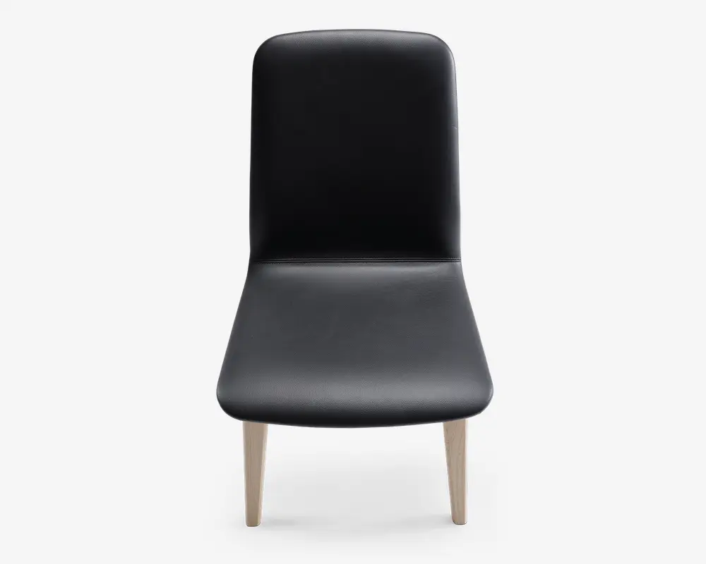Stol med glat, sort polstret sæde og ryglæn, med et minimalistisk design. Sædet og ryglænet er let buede for komfort, og stolen står på fire lyse træben, der er let vinklet udad.