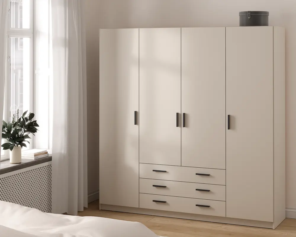 Et moderne, fritstående garderobeskab med mat beige finish. Skabet har fire høje låger med slanke, sorte rektangulære greb samt tre rummelige skuffer nederst i midten, alle med matchende sorte greb. Garderobeskabet har et rent, minimalistisk design og står direkte på gulvet. Øverst på skabet står en rund, grå opbevaringsboks.