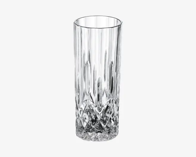 Højt, klart glas med cylindrisk form, der har et tekstureret, diamantmønstret design i bunden, som går over i lodrette riller langs siderne. Glasset har en glat kant og en solid, tung bund for stabilitet.