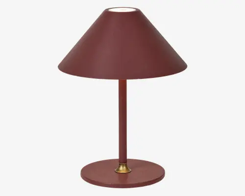 Bordlampe med mat, mørkerød finish. Lampen har en bred, konisk lampeskærm og en rund fod i samme farve. Den slanke midterstang har en lille messingdetalje ved foden, hvilket giver lampen et moderne og klassisk udtryk.