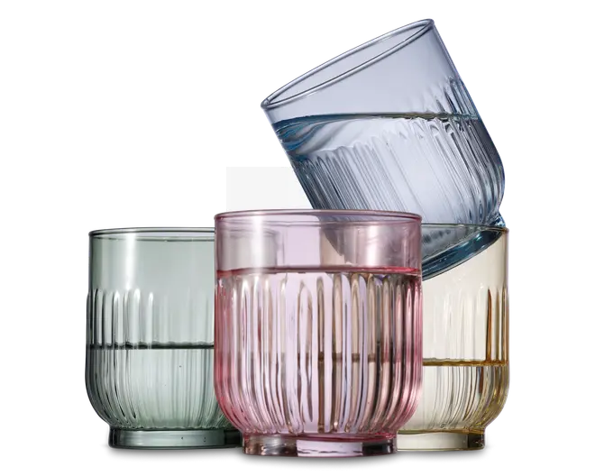 Sæt med fire lave drikkeglas, hver med rillet tekstur og en let rundet form. Glassene har forskellige transparente farver: lysegrøn, pink, gul og blå. Designet har lodrette riller, hvilket giver et stilfuldt og moderne udtryk.