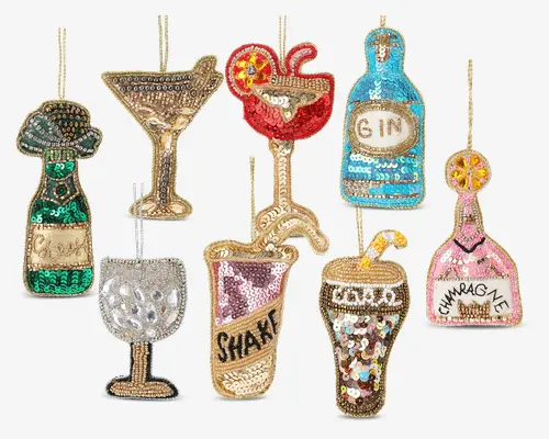 Sæt med otte dekorative ornamenter formet som forskellige cocktail- og drikkevarer, hver dækket af farverige pailletter og perler. Designene inkluderer en grøn og guld champagneflaske, et gyldent martiniglas, en rød cocktail med kirsebær, en blå ginflaske, et sølv vinglas, en pink shaker, et brunt og gyldent cocktailglas med citronskive samt en pink champagneflaske. Hvert ornament har detaljeret perlebroderi og glitrende udsmykninger, hvilket giver et festligt og glamourøst udtryk.