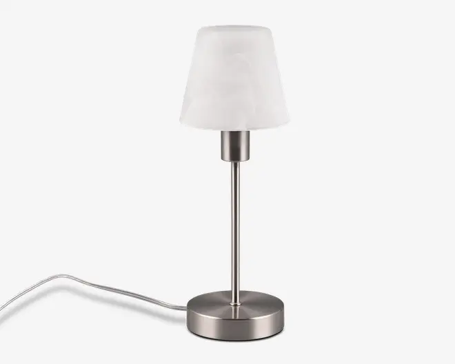 Moderne bordlampe med en børstet metalfod og -stamme i cylindrisk form. Lampen har en hvid, let konisk lampeskærm af mat materiale, som giver et blødt og diffust lys. Strømledningen er synlig og går ud fra bunden, hvilket gør lampen velegnet til skriveborde, sengeborde eller sideborde.