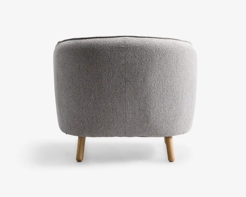 Rund puf med lysegråt tekstureret stofbetræk, har en glat, sømløs overflade og står på tre korte, cylindriske træben med naturfinish.
