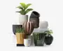 Et udvalg af dekorative urtepotter i forskellige former, størrelser og farver. Potterne har forskellige teksturer, herunder riflede, blanke, matte og piggede overflader. Farverne spænder fra hvid, sort og brun til gul, grøn og lyserød. Nogle potter har lodrette riller, mens andre har en glat eller mønstret finish. Flere potter indeholder grønne planter, hvilket viser deres anvendelse til indendørs dekoration.