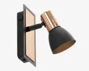 Væghængt spotlampe med en mat sort, konisk lampeskærm og en metallisk kobberdetalje øverst. Lampen har en rektangulær bagplade med en kobberfarvet indsats og sort ramme. Lampens hoved kan justeres, så lyset kan rettes i forskellige retninger.