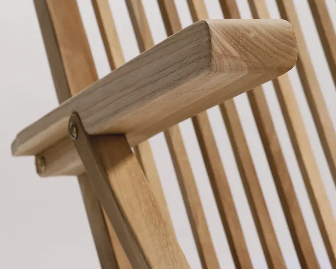 Nærbillede af et træarmlæn med en glat, afrundet kant og synlig træ continually. Armlænet module fastgjort til en ramme med trælameller ved hjælp af metalbeslag, hvilket viser en solid konstruktion og en naturlig finish. Designet fremhæver hånd ' pe og sans for detaljer bic egner sig til et moderne eller minimalistisk udtryk.