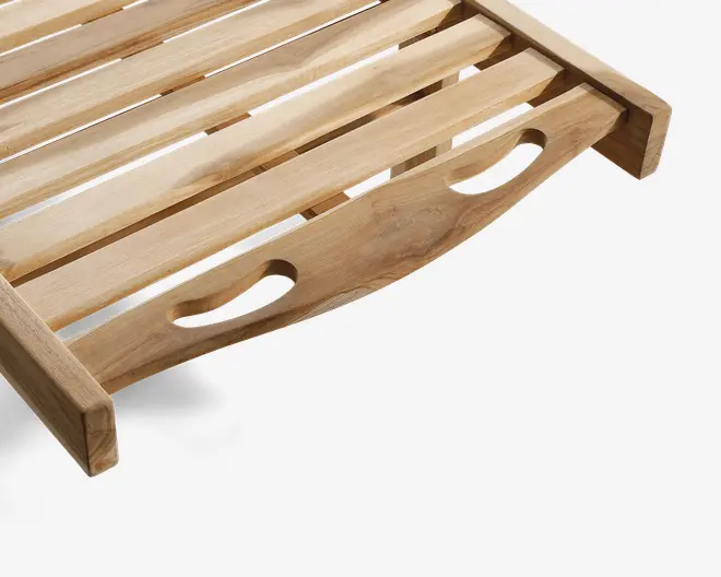 Nærbillede af en bakke i træ med naturfinish, udført med lameller for ventilation og dræning. Bakken har en buet side med to ovale udskårne håndtag, der gør den nem at bære. Træets årer er synlige, hvilket giver et rustikt og solidt udtryk.