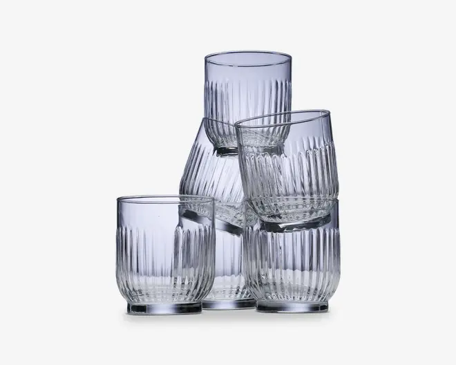Sæt med seks klare glas med moderne, cylindrisk form og lodret rillet struktur. Glassene har en tyk, solid bund og let afrundede kanter, hvilket giver et behageligt greb og et stilfuldt, moderne udtryk.