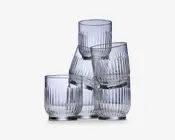 Sæt med seks klare glas med moderne, cylindrisk form og lodret rillet struktur. Glassene har en tyk, solid bund og let afrundede kanter, hvilket giver et behageligt greb og et stilfuldt, moderne udtryk.