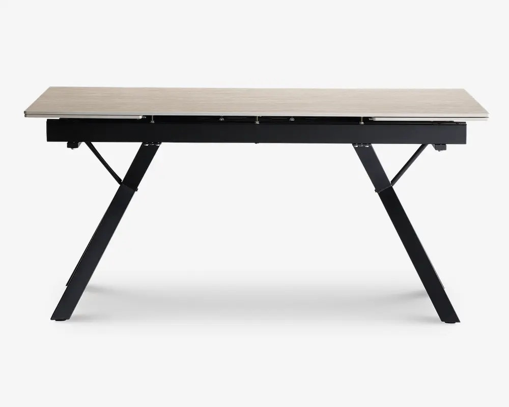 Rektangulært bord med en lys træbordplade og solidt sort metalstel. Bordet har skrå ben for ekstra stabilitet og et moderne, minimalistisk design. Overfladen er glat og rummelig, velegnet til forskellige formål som spisning, arbejde eller studier.
