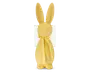 En glat, mat gul figur formet som en kanin med lange opretstående ører, et rundt hoved med en lille cirkulær næse og en enkel krop. Kaninen har et matchende gult bånd bundet i en sløjfe omkring halsen. Designet er minimalistisk uden ansigtsdetaljer udover næsen, og overfladen ser ud til at være lavet af et solidt materiale.