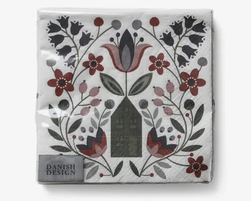 Dekorativ serviet med et symmetrisk skandinavisk folkekunst-design, der viser stiliserede blomster, blade og et centralt husmotiv. Farvepaletten består af afdæmpede røde, grønne og grå nuancer på hvid baggrund. Servietten har en let tekstureret overflade og et lille mærke i hjørnet med teksten 'Danish Design.'