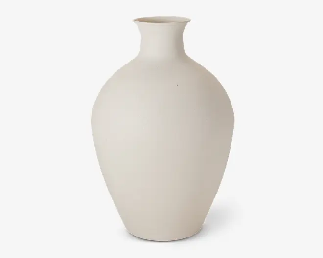 Høj vase med mat finish og en glat, offwhite overflade. Vasen har en klassisk, aflang oval form, der smalner ind mod bunden, samt en smal hals, der åbner sig let udad foroven. Designet er minimalistisk og uden dekoration, hvilket gør den velegnet til moderne eller nutidig indretning.