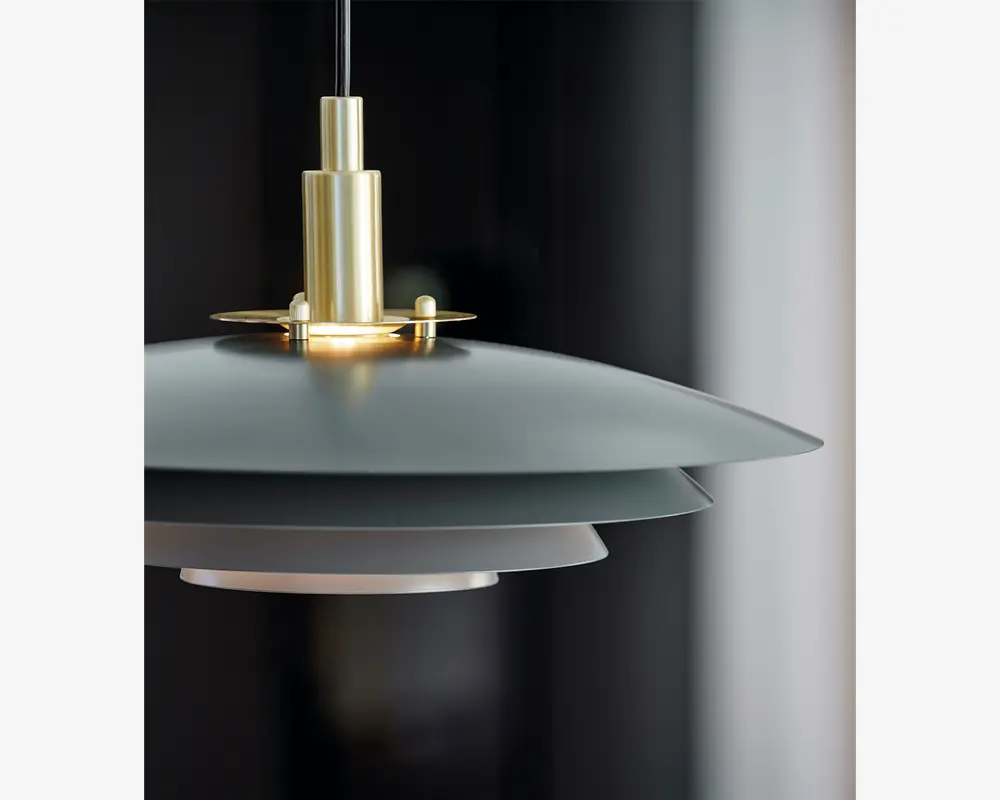 Loftlampe med et moderne, lagdelt design bestående af tre cirkulære, overlappende skærme i mat grå og hvid. Lampen har en beslag i børstet messing øverst, hvilket giver et elegant udtryk. Skærmene er arrangeret, så lyset spredes jævnt og blænding minimeres, hvilket gør lampen velegnet til stemningsbelysning i moderne indretninger.