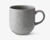 En glat, rund keramikkop med en blank lysegrå overflade. Koppen har et behageligt, buet håndtag og en let tilspidset bund, hvilket giver et moderne og minimalistisk udtryk. Indersiden er også glaseret i samme lysegrå farve, og kanten er diskret markeret.