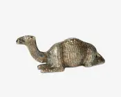 En dekorativ figur formet som en hvilende kamel med en tekstureret overflade og et metallisk, let patineret udseende. Kamelen ligger ned med benene trukket ind under kroppen og hovedet løftet. Overfladen har fine detaljer, der efterligner kamelens pels og former, med diskrete nuancer af blå og brune farver.