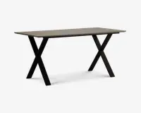 Rektangulært bord med en lys, glat bordplade og solide sorte metalben, der er krydset i et X-formet design i hver ende. Bordet har et minimalistisk og moderne udtryk og giver en rummelig overflade, der egner sig til både spisning, arbejde eller andre aktiviteter.