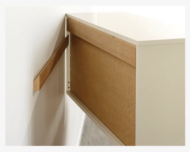 Billedet viser bagsiden af et hvidt skab med en træstøtteskinne monteret på væggen. Skabet er beregnet til vægmontering, og støtteskinnen giver stabilitet og hjælper med at fastgøre skabet. Bagpanelet er lavet af spånplade, og oversiden har en glat, blank hvid finish.