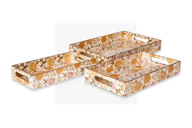 Sæt med tre rektangulære bakker i forskellige størrelser, hver med et livligt blomstermønster i nuancer af guld, pink og hvid. Bakkerne har udskårne håndtag i de korte sider for nem transport, og blomstermotivet dækker både inderside og yderside. Bakkerne kan stables for praktisk opbevaring.