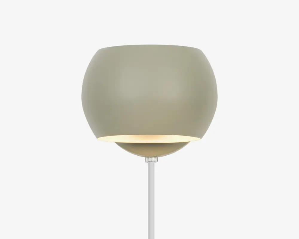 Moderne væglampe med en glat, mat lysegrå overflade. Lampen har en rund, skålformet skærm med en let åben bund, der lader lyset skinne nedad. Designet er minimalistisk og nutidigt, med en slank stang, der forbinder skærmen til vægbeslaget.