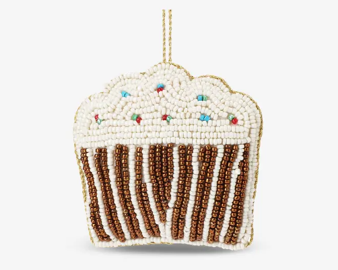 Pynt formet som en cupcake, dekoreret med små perler. Den nederste halvdel har lodrette striber i skiftevis metallisk bronze og hvide perler, der ligner en cupcake-form. Toppen er dækket af hvide perler for at ligne glasur, med spredte røde, blå og grønne perler som krymmel. Øverst sidder en guldfarvet løkke til ophængning.