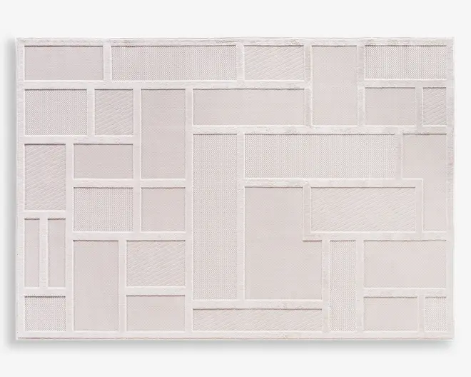 Rektangulært produkt med et geometrisk patchwork-design bestående af rektangler og firkanter i forskellige størrelser. Overfladen er tekstureret, hvor hvert felt har et let forskelligt mønster eller vævning, alt sammen i en ensartet lys beige eller offwhite farve. Kanterne på hver form er markeret med hævede sømme, hvilket giver en diskret tredimensionel effekt.