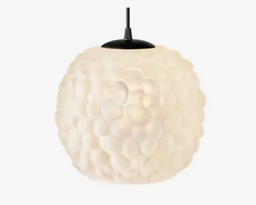 Kugleformet pendellampe med en tekstureret overflade, der ligner en bikube, lavet af mat hvidt glas. Lampen udsender et blødt, diffust lys og har en sort metalfatning i toppen til ophængning. Den unikke overfladestruktur giver et moderne og kunstnerisk udtryk.