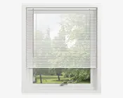 Hvide vandrette lamelgardiner, der er delvist trukket ned foran et vindue, så naturligt lys filtreres ind. Lamellerne er jævnt fordelt og lavet af et let materiale, hvilket giver privatliv, men stadig mulighed for at se ud. Vinduesrammen er hvid, og gardinet har et rent og moderne udseende.