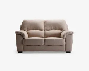 En to-personers sofa med blødt, lysebeige stofbetræk. Sofaen har fyldige, polstrede ryghynder og brede, polstrede armlæn for ekstra komfort. Sædehynderne er tykke og let buede foran, hvilket giver ergonomisk støtte. Sofaen står på korte, solide sorte ben.