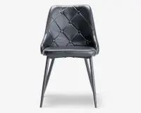 Stol med sort kunstlæderbetræk og et ryglæn med diamantmønster og knapper. Sædet er polstret for ekstra komfort, og stolen har fire slanke, let tilspidsede ben i metal med en mørk finish. Designet er moderne og elegant.