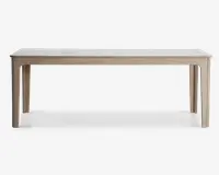 Rektangulært bord med en glat, lysefarvet bordplade og matchende træben. Bordet har et minimalistisk design med rene linjer og en diskret træstruktur på ben og ramme. Bordpladen ser ud til at være lavet af et solidt, lyst materiale, muligvis laminat eller malet træ, og benene er let tilspidsede for et moderne udtryk.