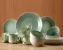 Et sæt keramikservice med en blød grøn glasur og diskrete farveovergange. Sættet indeholder store middagstallerkener, mindre sidetallerkener, skåle og krus. Hver del har en glat, let blank overflade og et minimalistisk design med blødt buede kanter. Krusene har komfortable, afrundede hanke, og skålene er dybe med en bred åbning. Farven går fra en lys grøn ved kanten til en dybere grøn mod midten, hvilket giver hvert stykke et håndlavet, kunstnerisk udtryk.