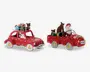 To festlige røde køretøjer med hvide prikker, hver med en julemandsfigur som chauffør. Det første køretøj er en bil med en stak farverige indpakkede gaver og et brunt rensdyr på taget. Det andet køretøj er en pickup med en stor brun sæk, flere indpakkede gaver og et rensdyr på ladet. Begge køretøjer har hjulkapsler med guldfarvede stjerner og sjove nummerplader med teksten 'Oh oh oh' og 'Ho Ho Ho.'