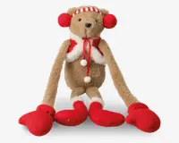 Bamse med lange arme og ben, iført røde vanter, røde støvler, rød- og hvidstribet hue samt røde ørevarmere. Bamsen har også et hvidt og rødt tørklæde med blødt hvidt kant og pomponer. Pelsen er lysebrun, og næsen er sort.