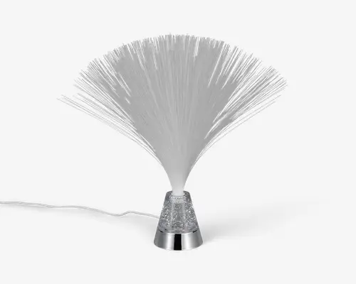 Dekorativ lampe med en vifteformet samling af fine, gennemsigtige fiberoptiske tråde, der spreder sig ud fra en central base. Basen er i metallisk sølv med en klar sektion fyldt med glimmer, og lampen har en synlig ledning til strøm. Fibrene lyser op, når lampen tændes, og skaber en glitrende, lysdiffuserende effekt.